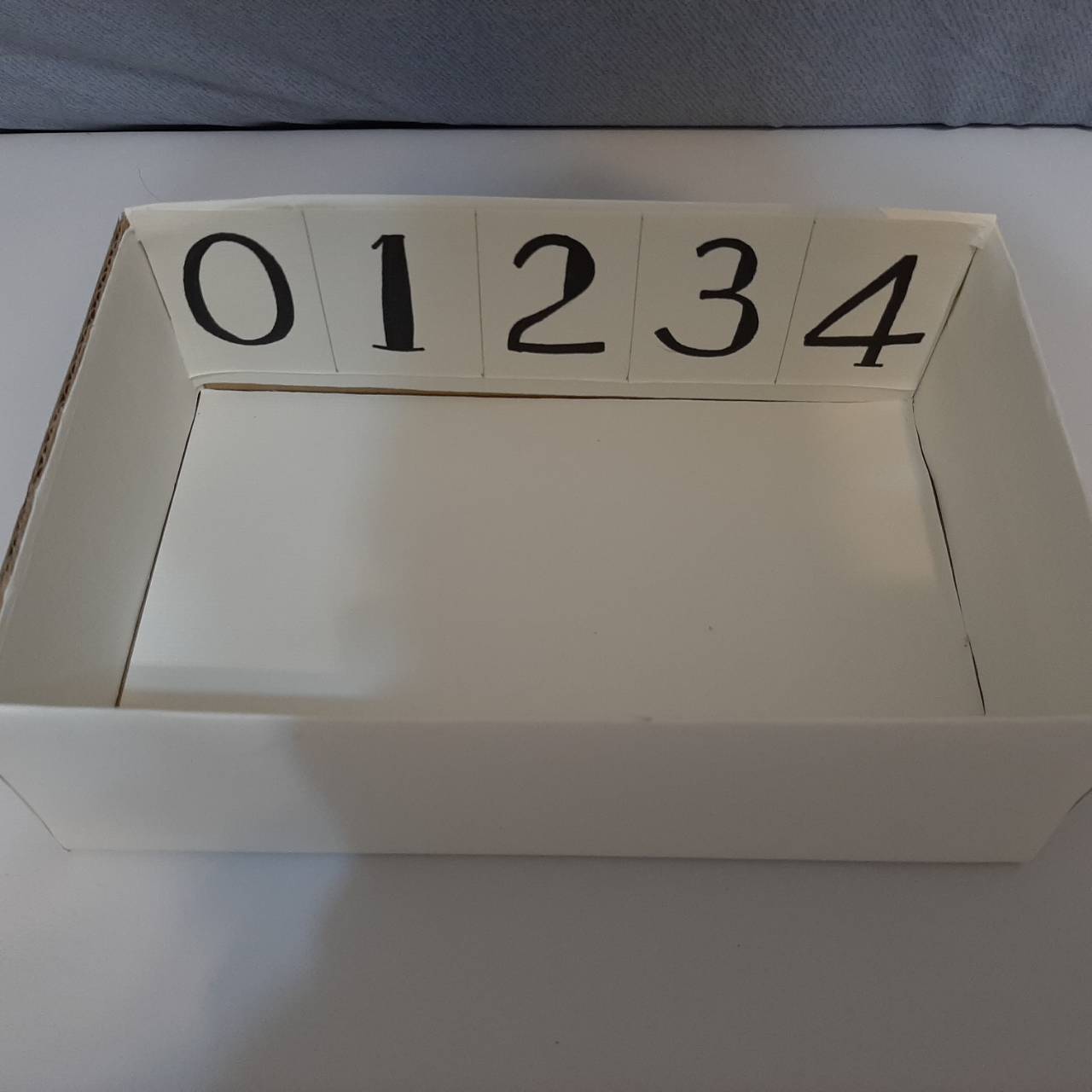 裁切紙箱,保留底部約8~10公分,包裝後寫上數字0~4